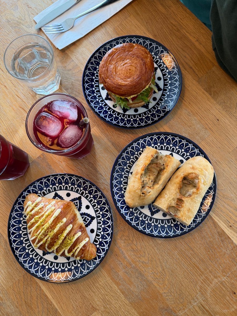 Quiche, sandwich sur brioche et sandwichs sur ciabatta servis sur de jolies assiettes bleues.