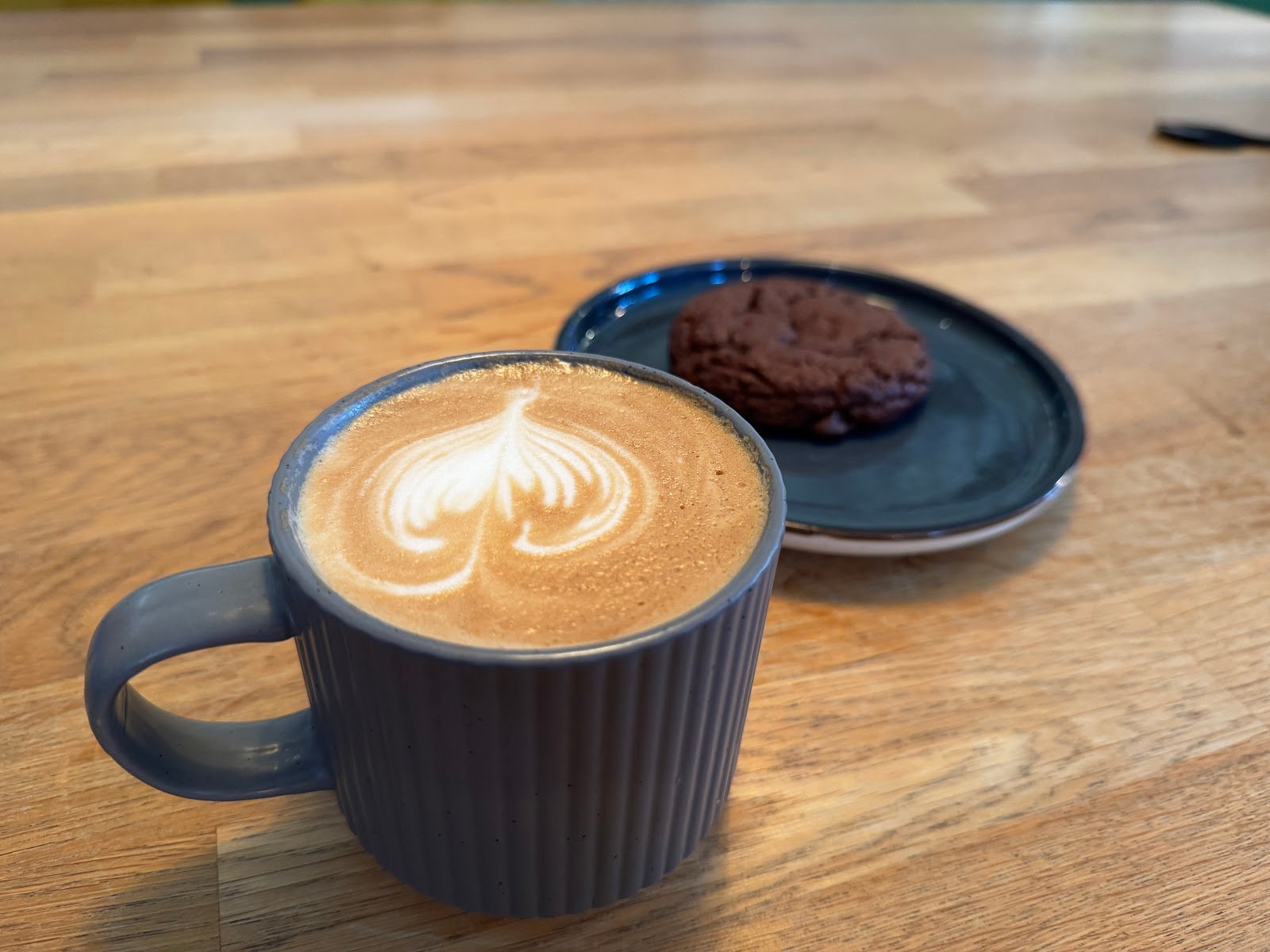 Latte à la belle mousse dessinée en rosetta, servi dans une tasse en céramique.